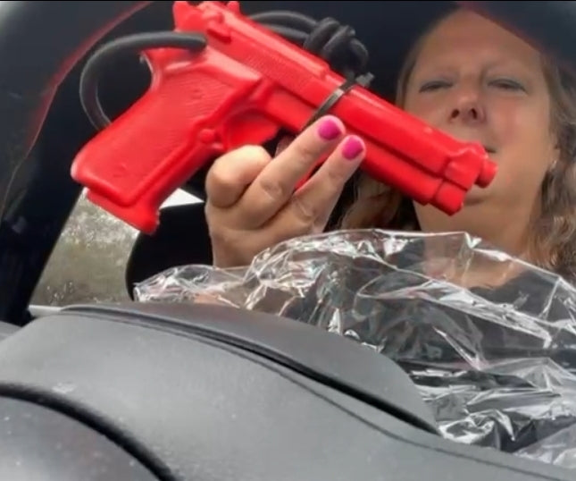 Customer holding red GRUPS® grip trainer inside car, unboxing for strength training and self-defense practice.