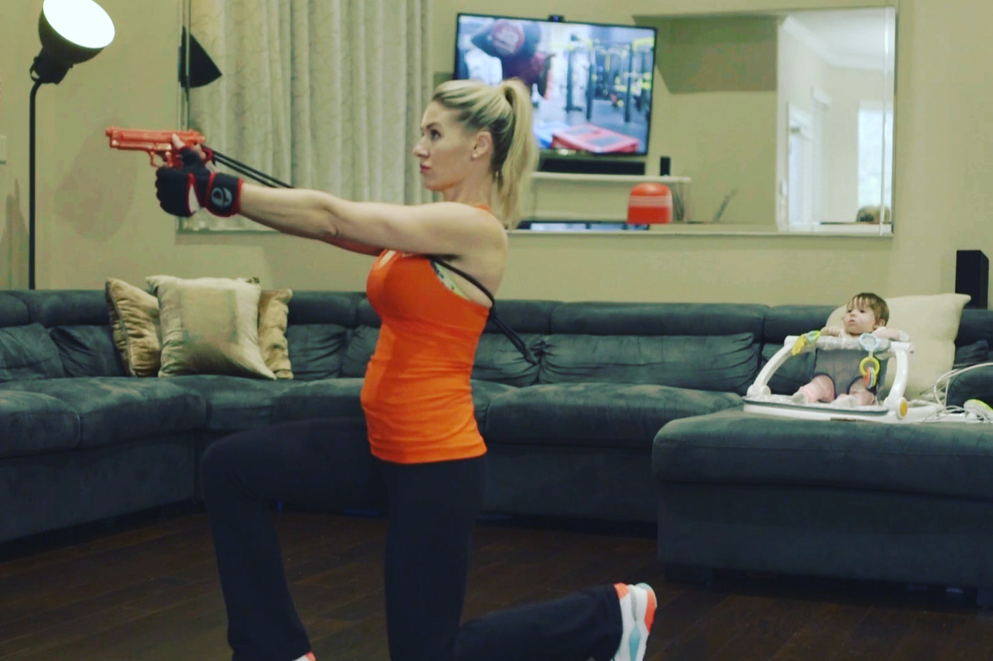 Woman training at home with GRUPS® Grip Trainer while child watches nearby, demonstrating strength and safety for parents. Self-Defense training activity at home.