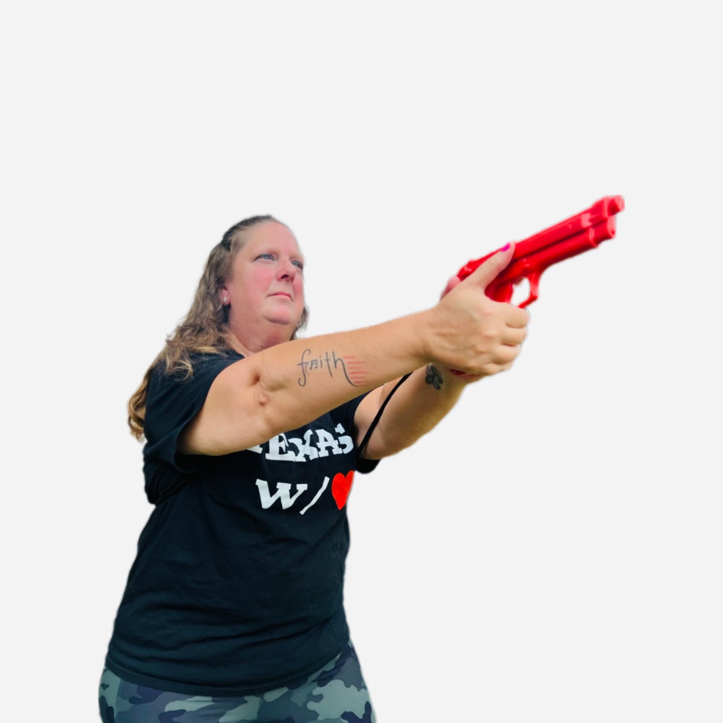 Woman wearing From Texas W/❤️ shirt using GRUPS® Grip Trainer, showing self-defense training, empowerment and strength with faith tattoo visible.